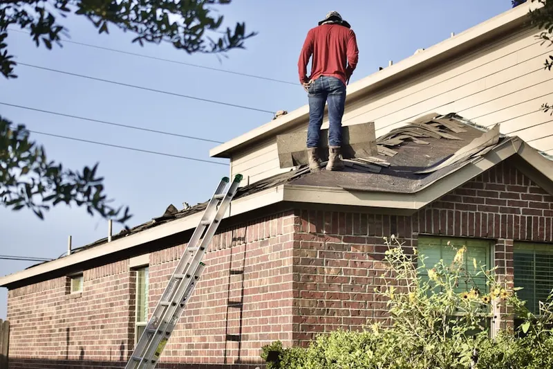 Professional roofer working on a residential roof in Dupont